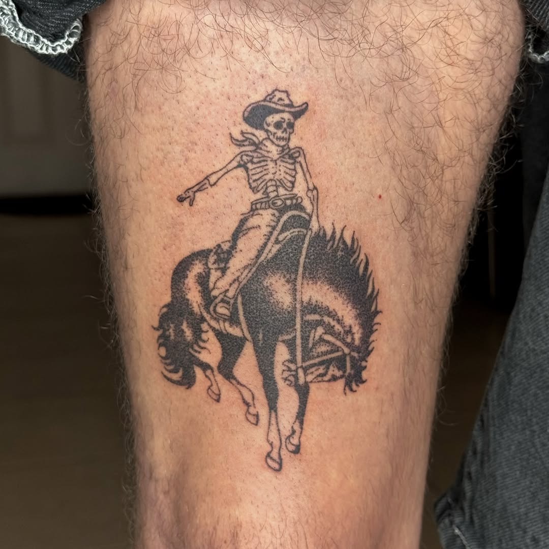 Skeleton cowboy riding a bucking horse ignorant tattoo on the thigh by Joint Killer