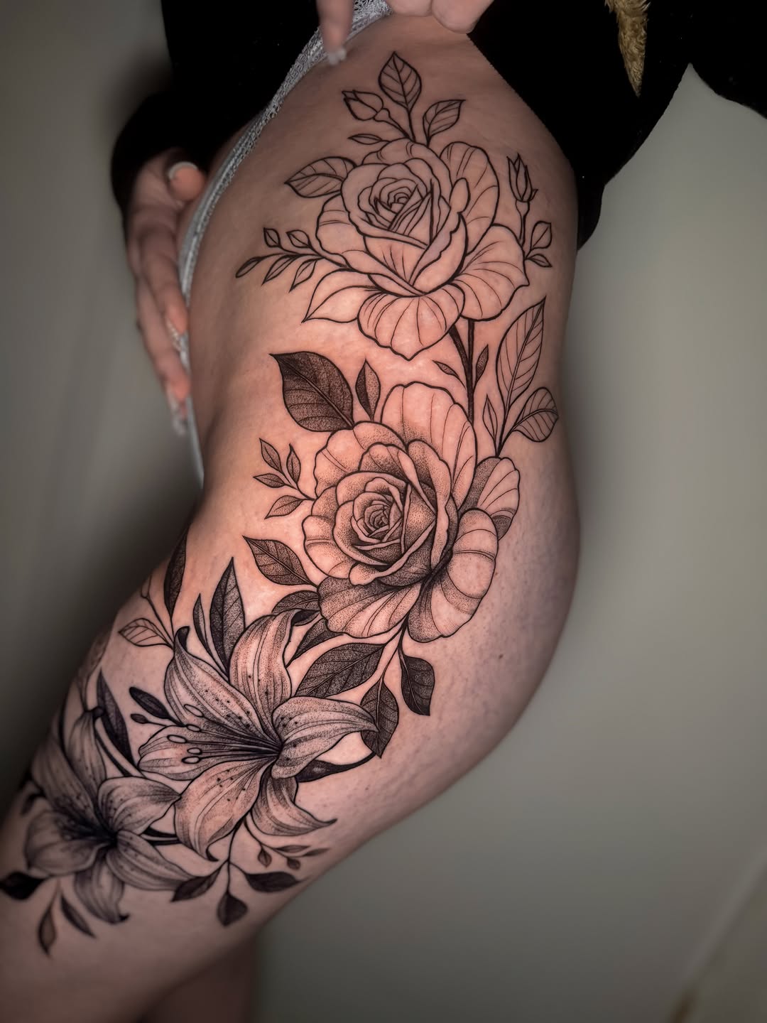 Roses and lilies dotwork tattoo on the thigh by Montreal Tattoo Artist