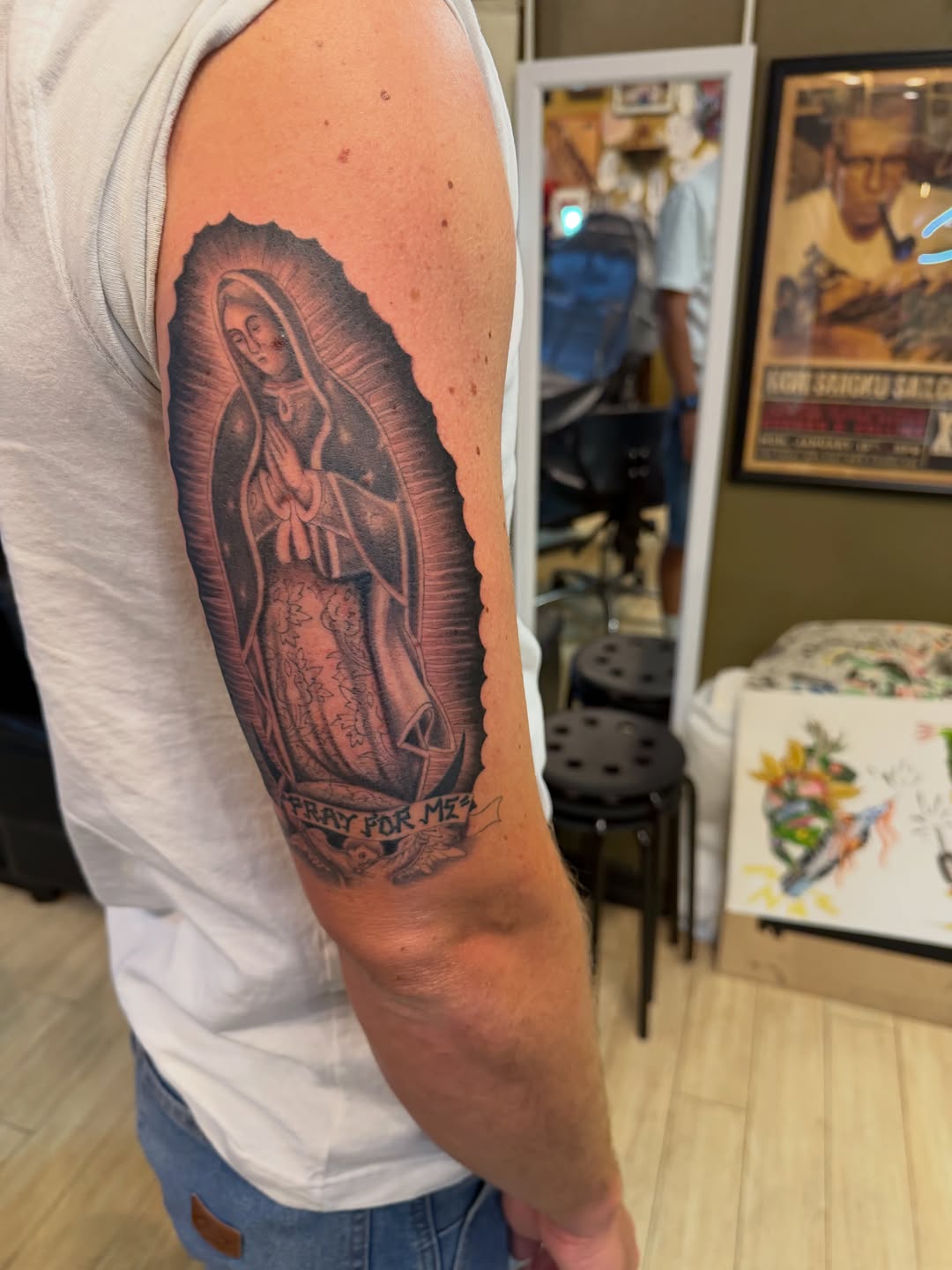 Virgin Mary with halo and banner Chicano tattoo on the forearm by Winston Thai