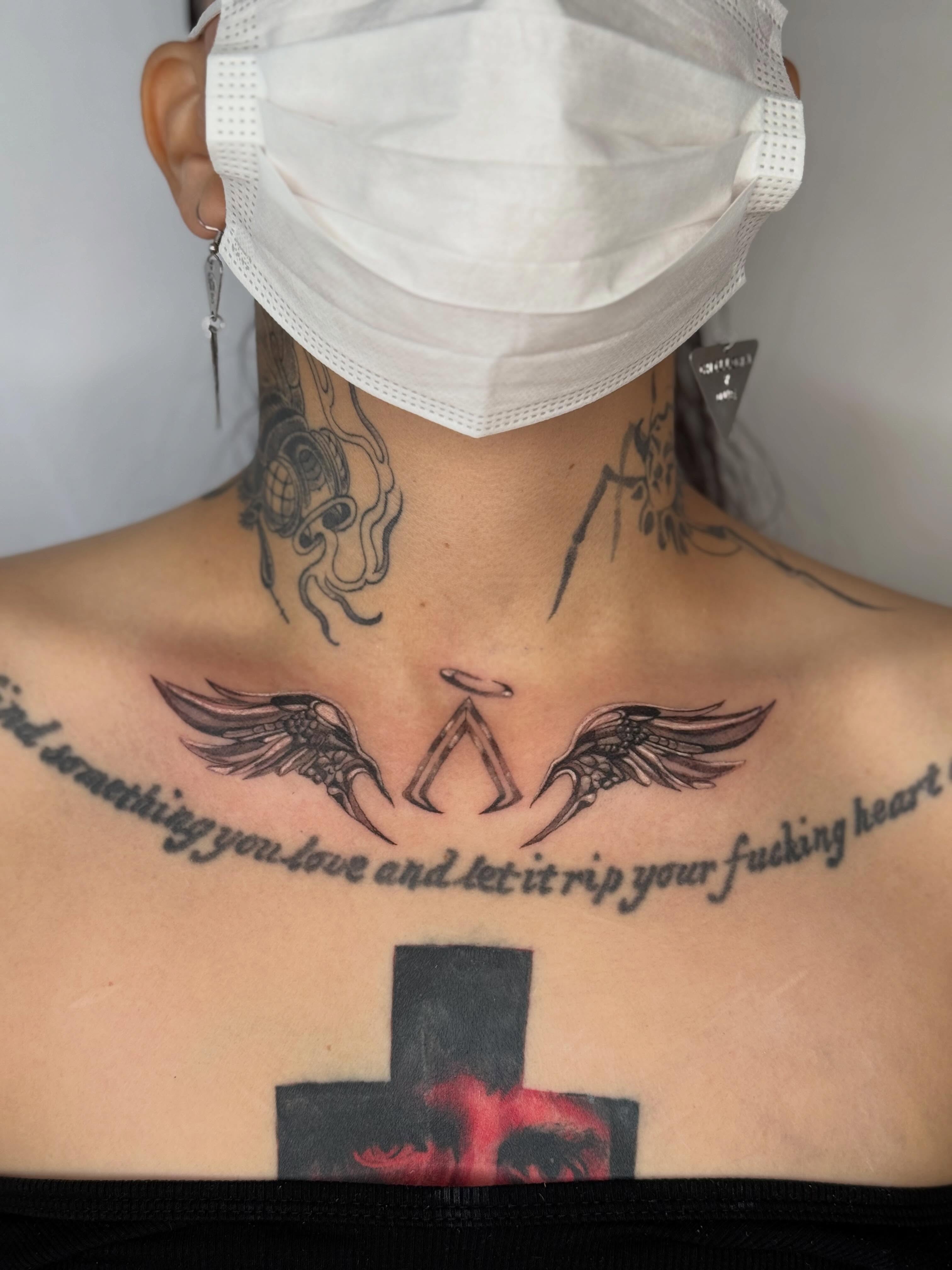 Wings and angelic figure black and grey tattoo on the chest by Em Krieg