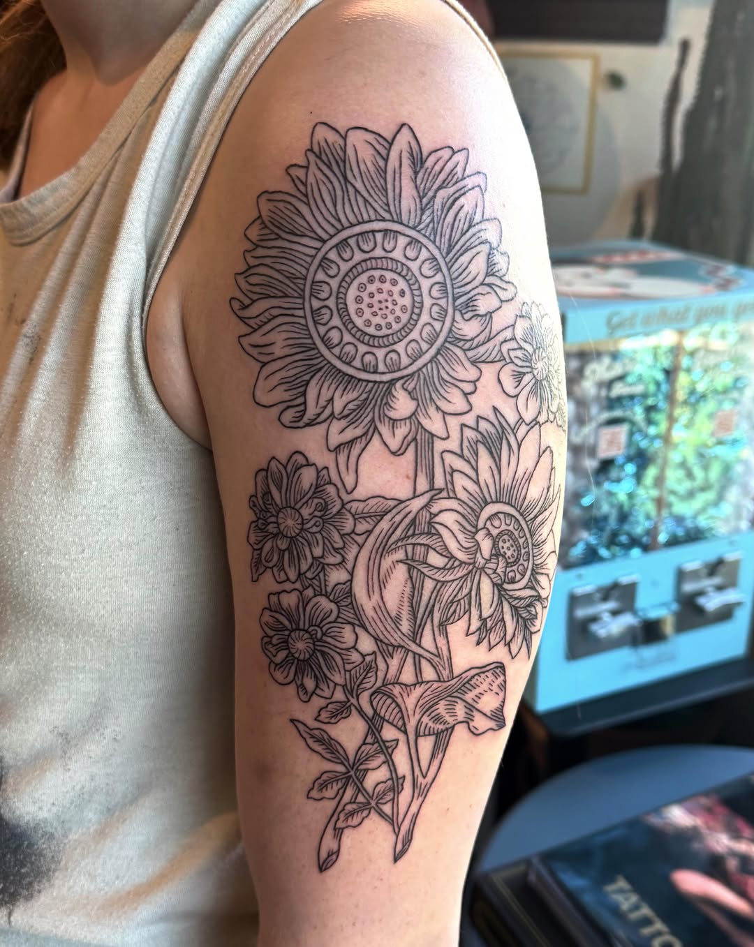 Sunflowers and other flowers fine line tattoo on the upper arm by Luna Enriquez⚡️, Portland, Oregon