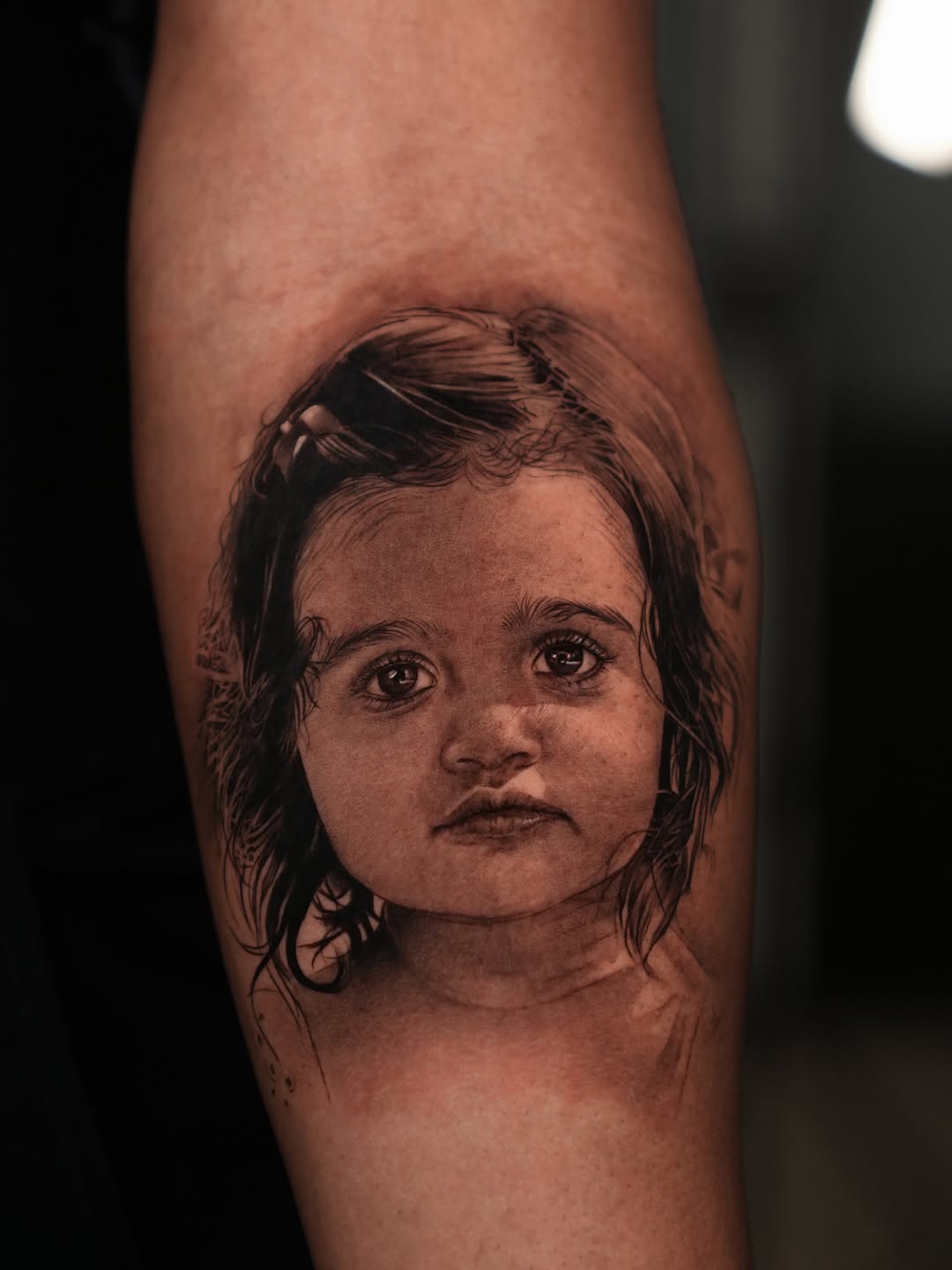 Portrait of a child realism tattoo on the forearm by J O S S I e L P I N e D A