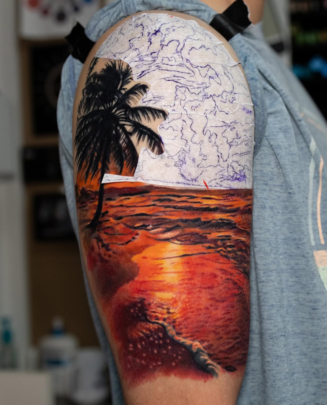 Tropical sunset beach scene fine line tattoo on the upper arm by Realistic tattoos in Minneapolis, MN, Minneapolis, Minnesota
