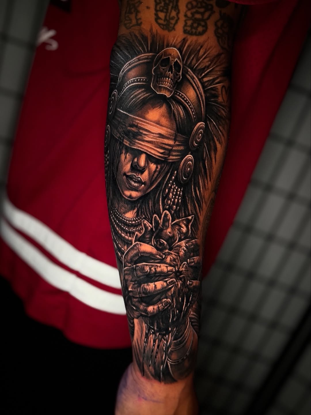 Blindfolded woman holding a heart realism tattoo on the forearm by Anthony Ramirez