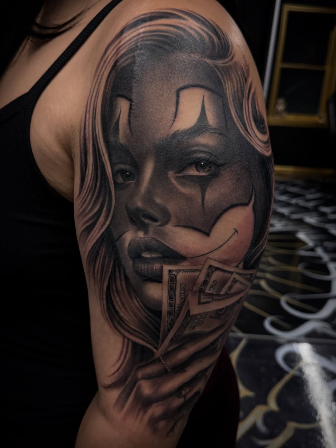 Woman with clown makeup and money Chicano tattoo on the forearm by Gee Lagunas 🇲🇽, Springfield, Virginia