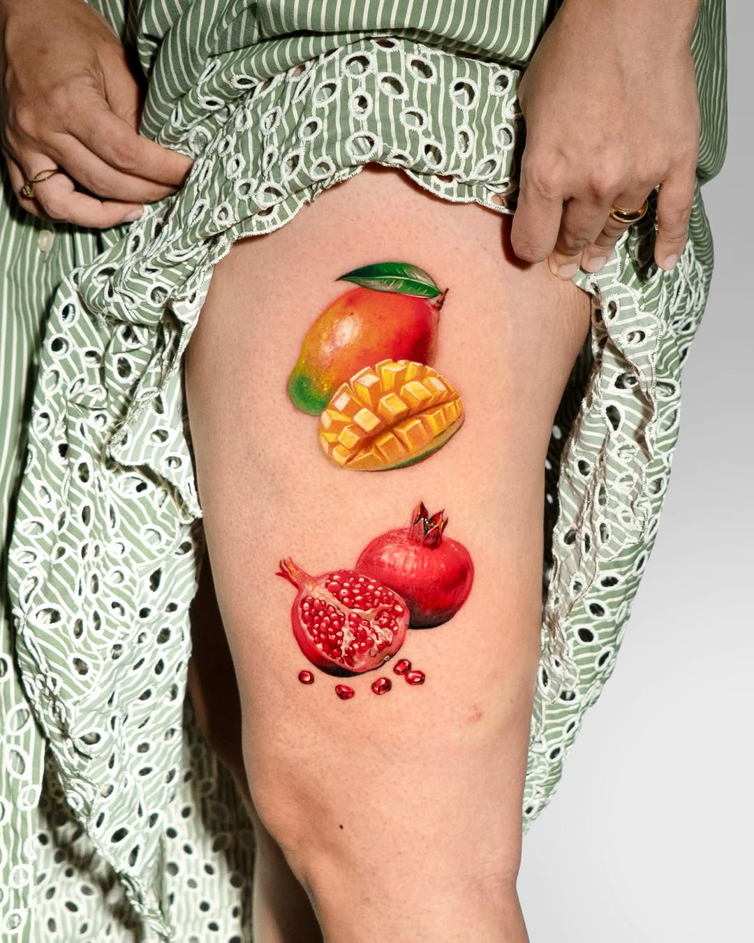 Mango and pomegranate watercolor tattoo on the thigh by Tattooist HARRY COLOR