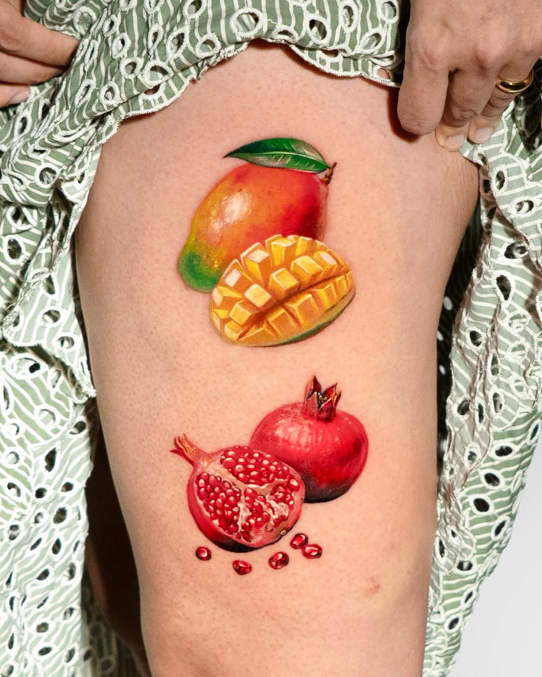 Mango and pomegranate watercolor tattoo on the thigh by Tattooist HARRY COLOR