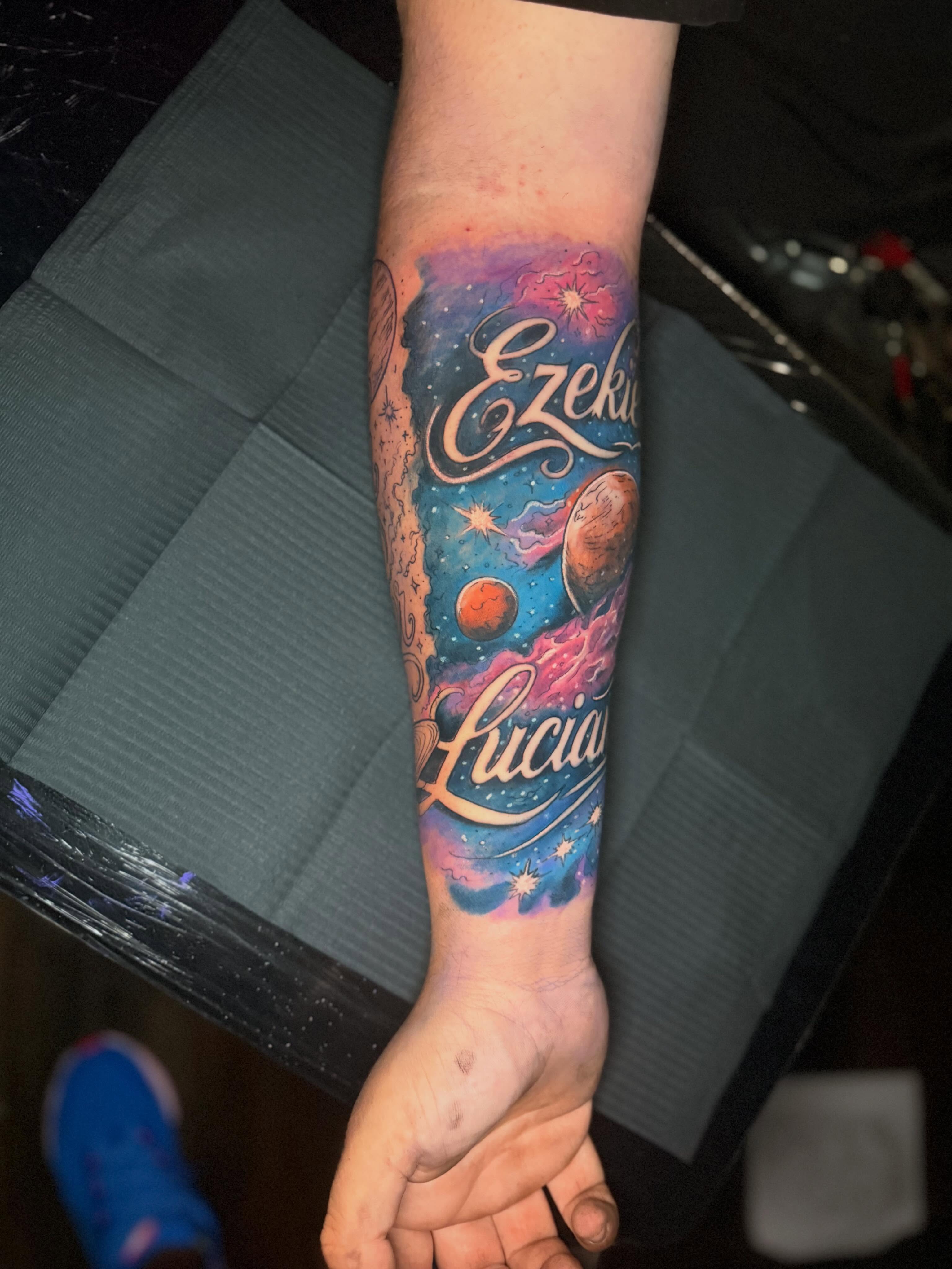 Space-themed tattoo watercolor tattoo on the forearm by Christopher Allman, Cheviot, Ohio
