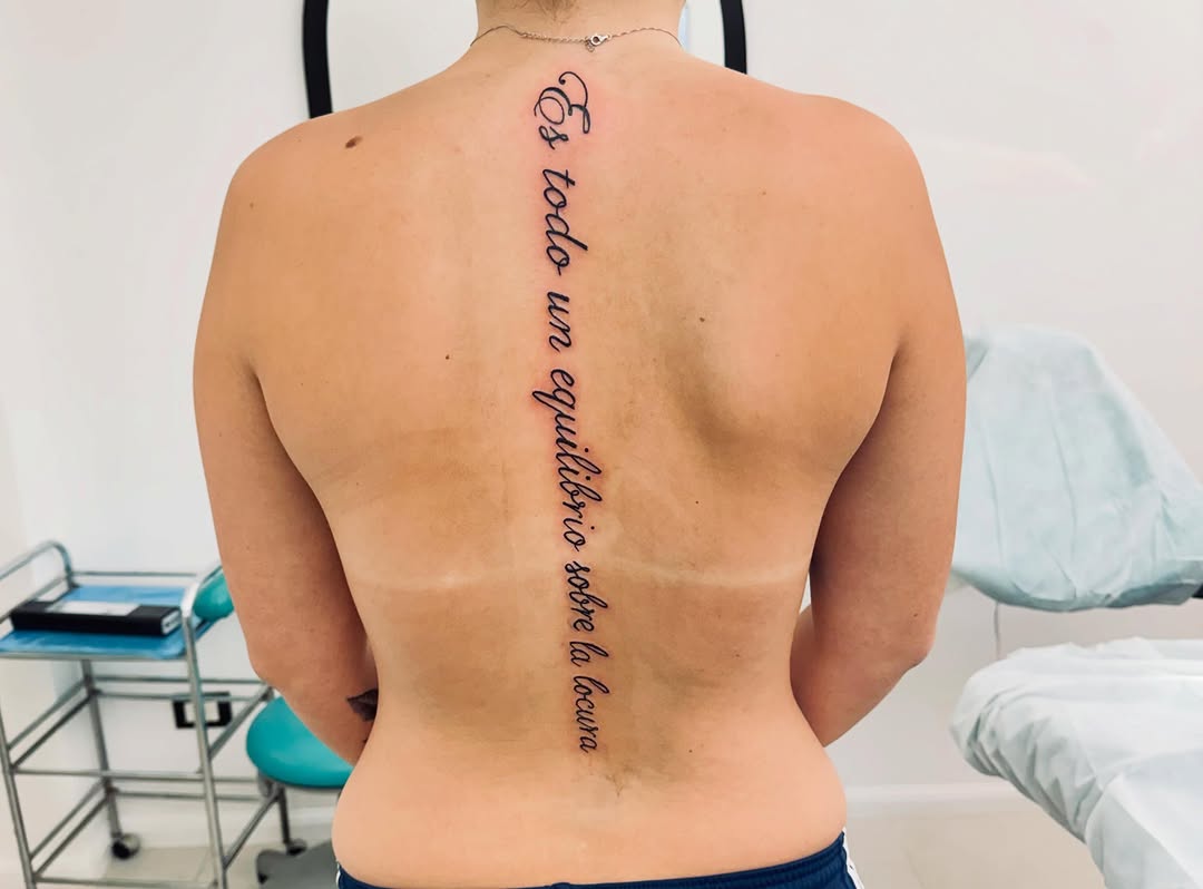 Script lettering on spine lettering tattoo on the back by Salvador Mendoza, Sesto San Giovanni