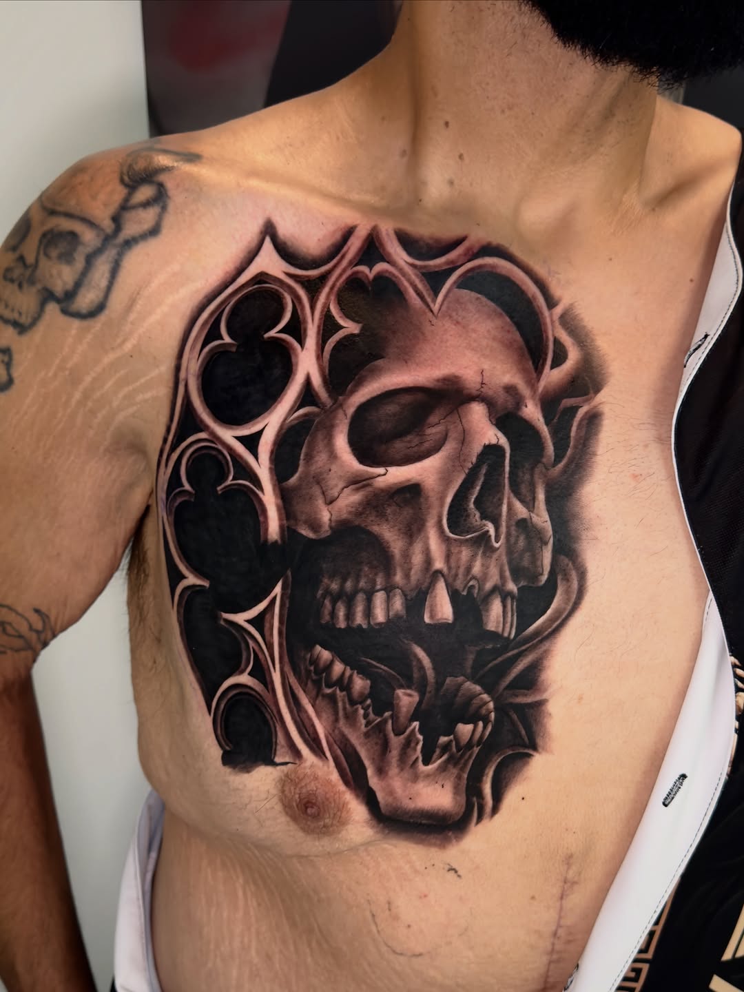 Skull with gothic frame realism tattoo on the chest by Brandon Patino