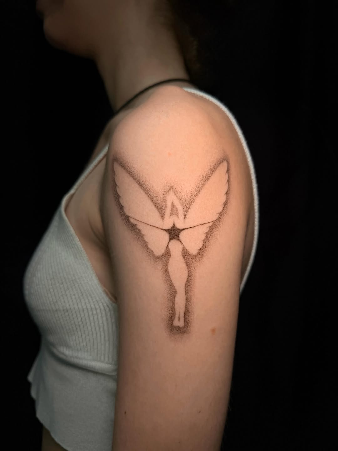 Angel silhouette realism tattoo on the shoulder by Frida Tattooista