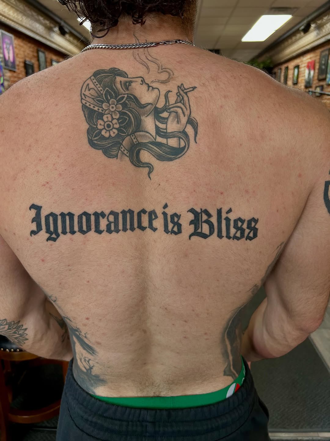 Woman smoking and text tattoo on the back by Bjorn Bjornstad, Dubuque, Iowa