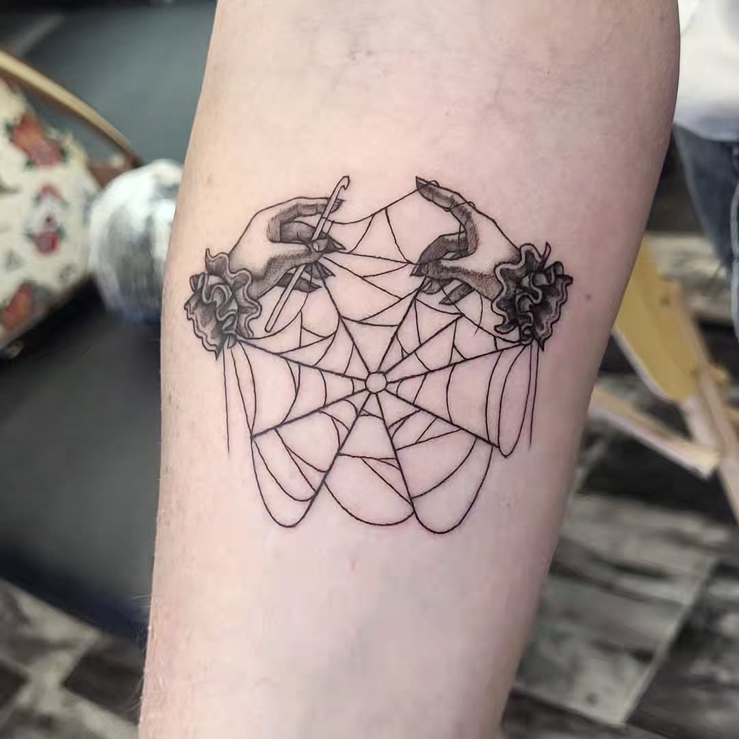 Hands crocheting a spiderweb minimalist tattoo on the forearm by TEA ☕️ Tattoos