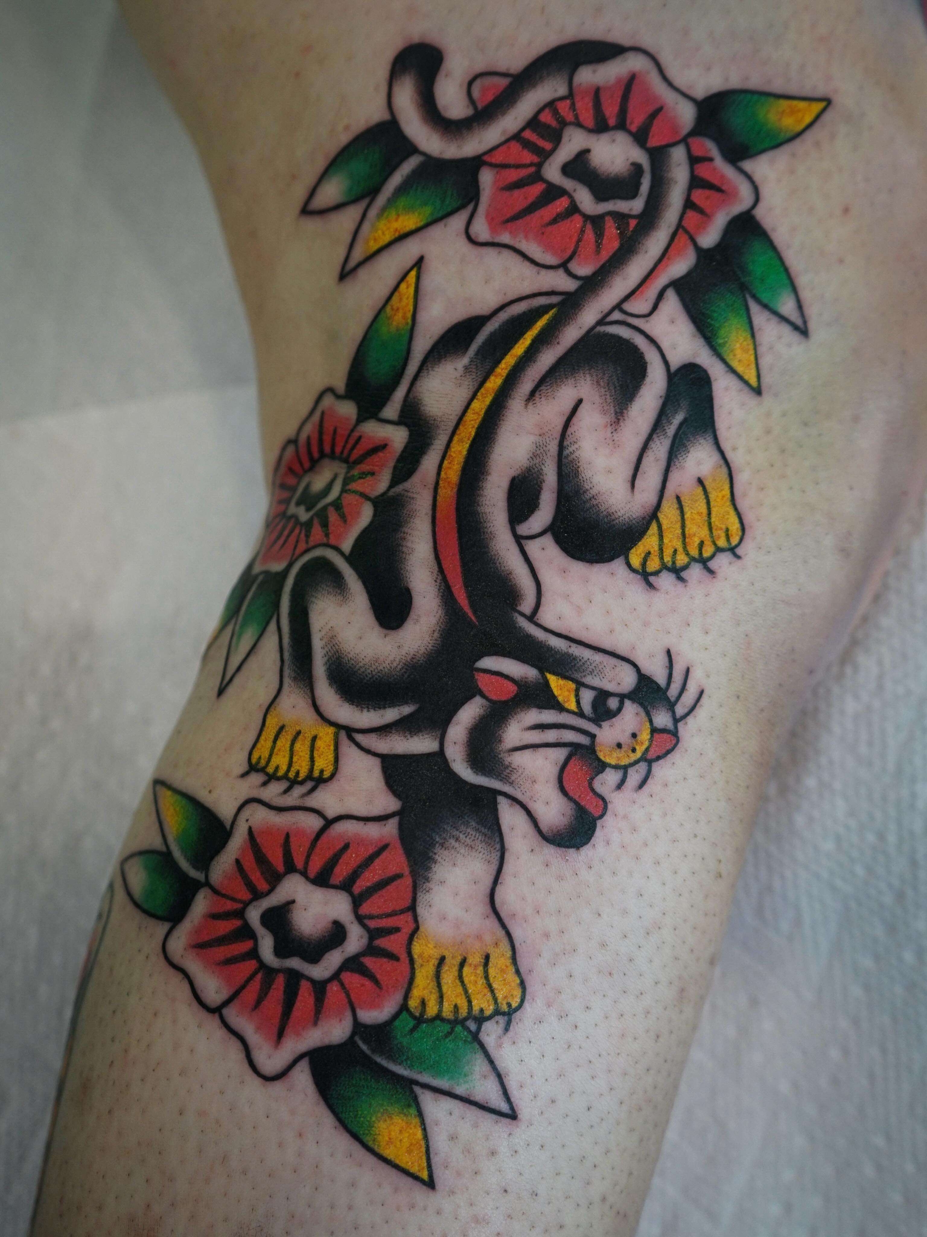 Panther and flowers American traditional tattoo on the thigh by Emily Devenz