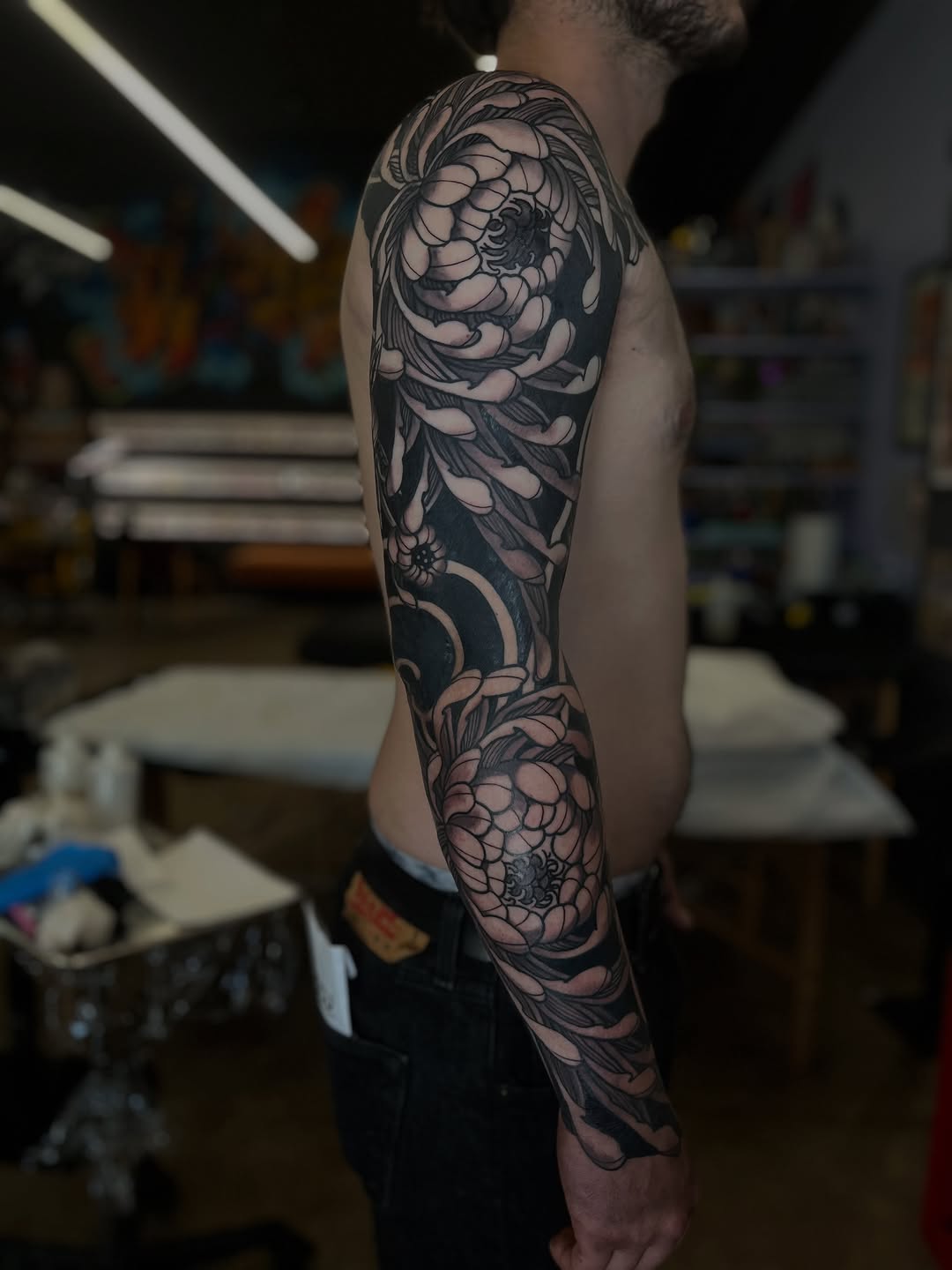 Chrysanthemum sleeve Japanese tattoo on the forearm by Kaichi Fujita, Eugene, Oregon
