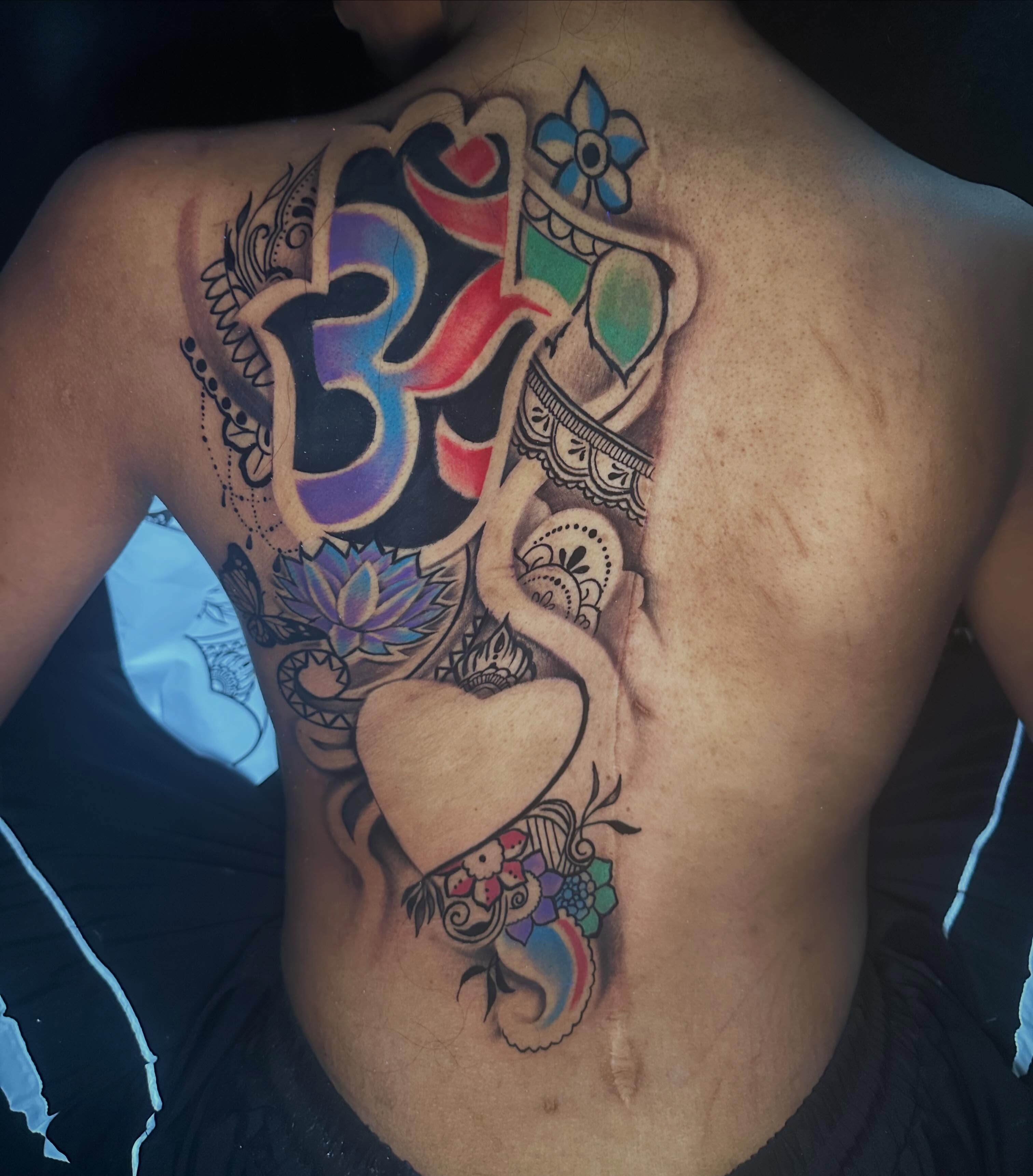 Om symbol with floral elements ornamental tattoo on the back by I Am Mawlo! Welcome Fellow Mawlonians