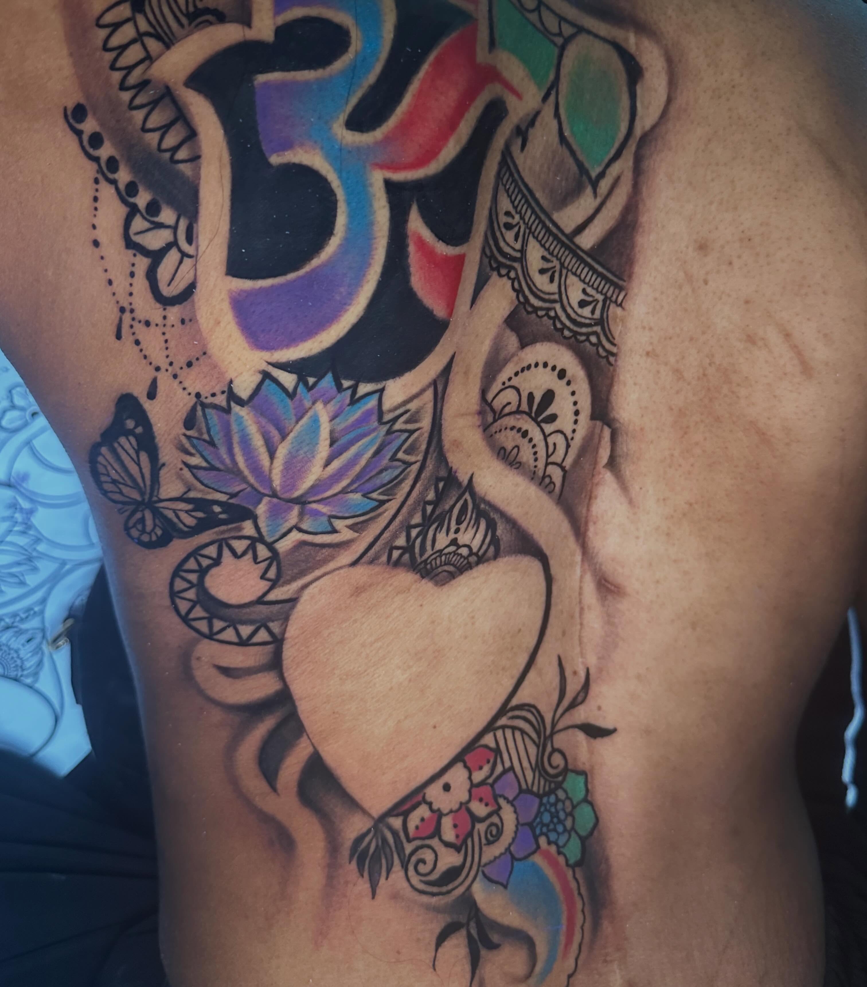 Om symbol and floral elements neo-traditional tattoo on the ribs by I Am Mawlo! Welcome Fellow Mawlonians