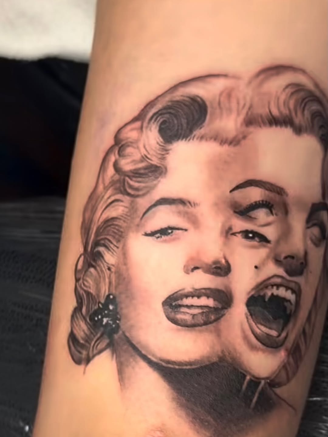 Marilyn Monroe portrait with fangs surrealism tattoo on the forearm by Charlotte Tattoo Artist💉