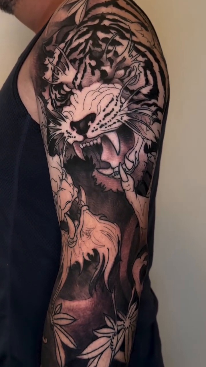 Tiger and floral sleeve Japanese tattoo on the upper arm by Mike Nance
