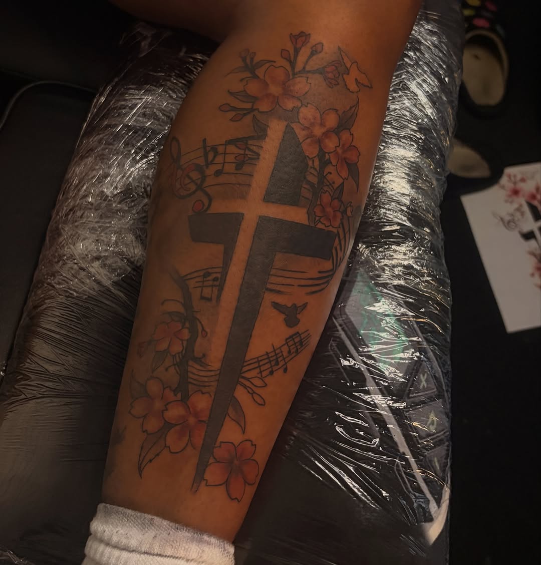 Cross with flowers and music notes tribal tattoo on the forearm by Female Cleveland Tat Artist ๐