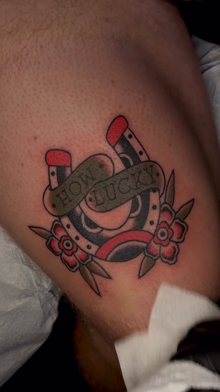 Horseshoe with "How Lucky" American traditional tattoo on the shoulder by Danelle ✶ Nashville Tattooer