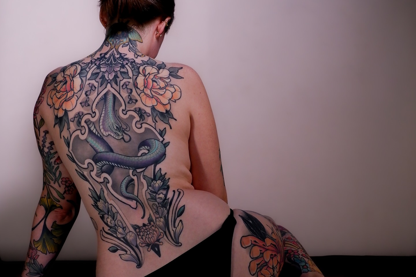 Snake and floral American traditional tattoo on the back by Joshua Weeks