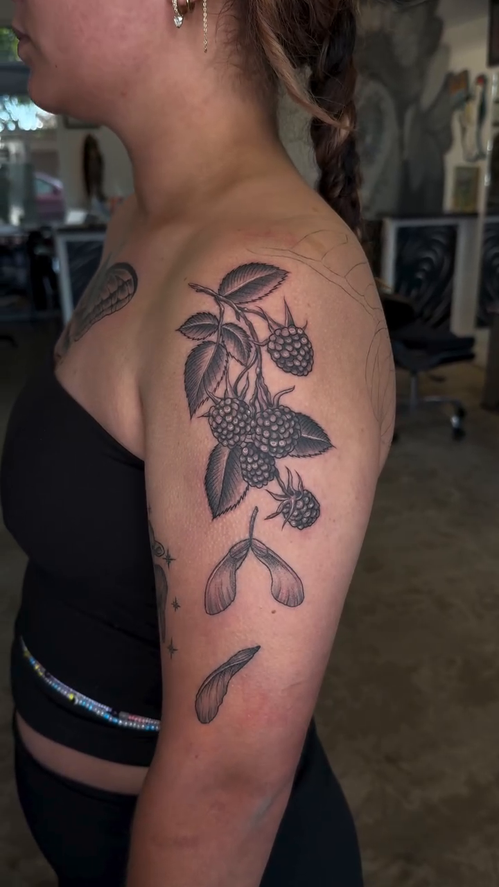 Raspberry branch with leaves and seeds dotwork tattoo on the upper arm by Ricky Sanchez, Duncanville, Texas