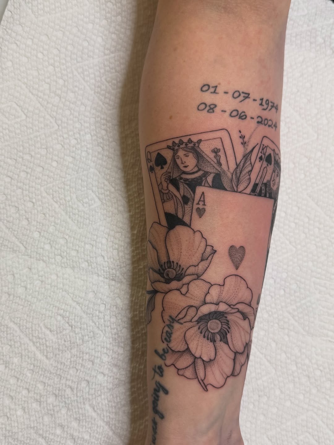 Playing cards, flowers, and dates tattoo on the forearm by WhoisLaineyTattoos