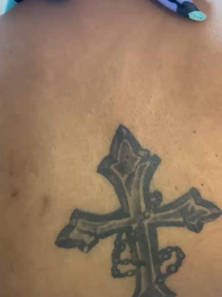 Cross with rosary beads tattoo on the torso by Mwangaza Bodyworks, Uthiru, Nairobi Area, Kenya