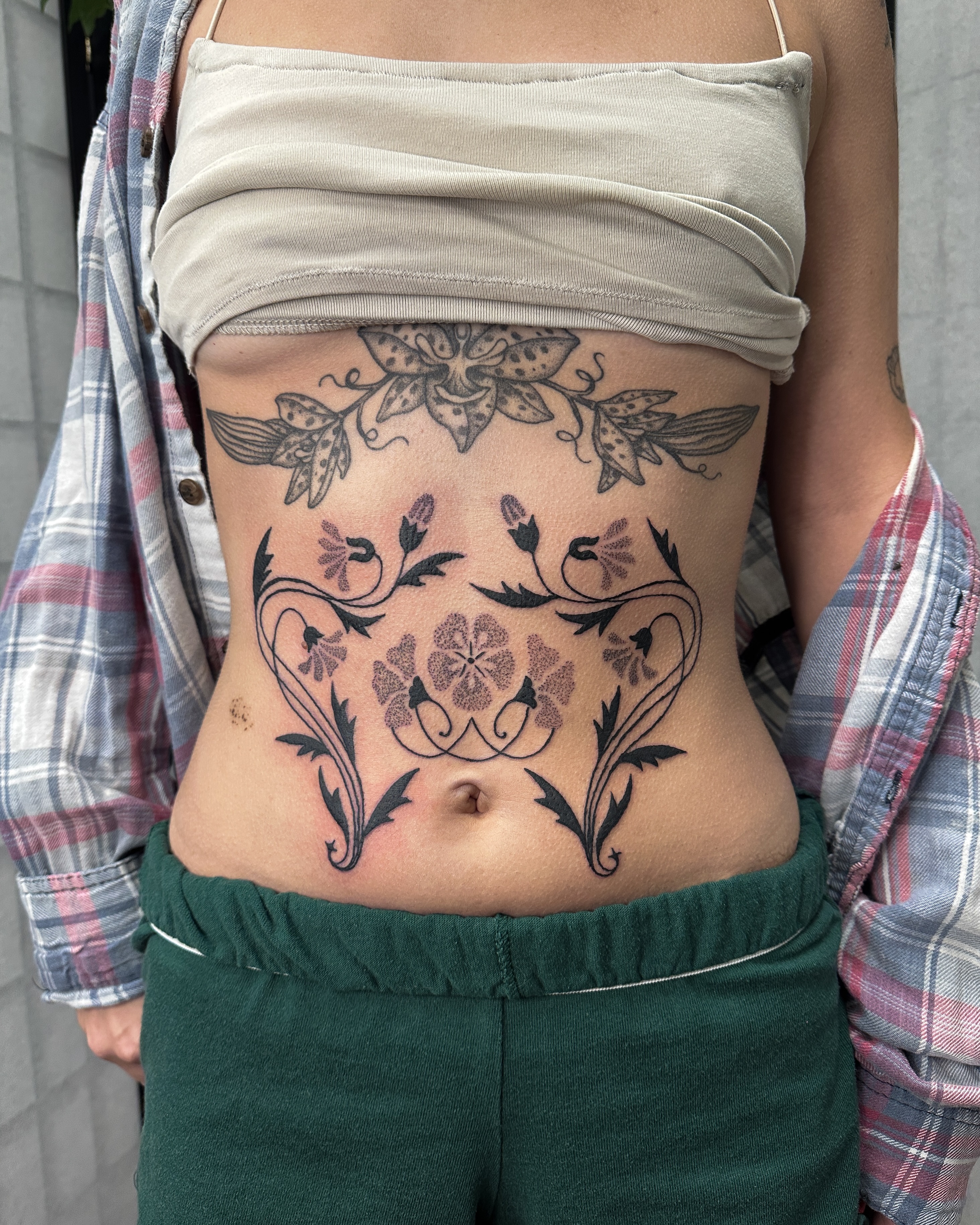 Floral design ornamental tattoo on the torso by Hannah Eddy
