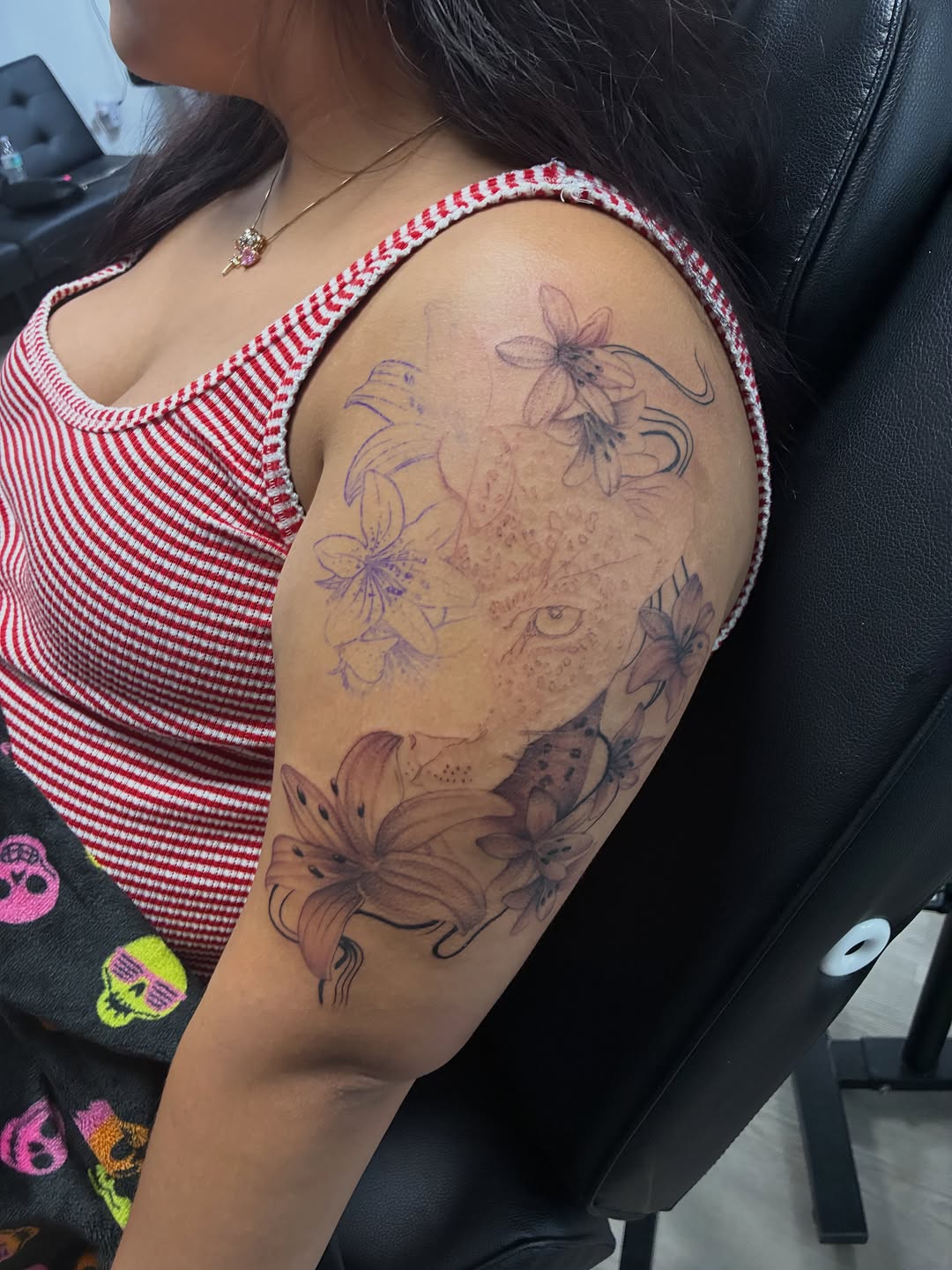 Leopard and lilies fine line tattoo on the shoulder by Tattzbyluma, Charlotte, North Carolina