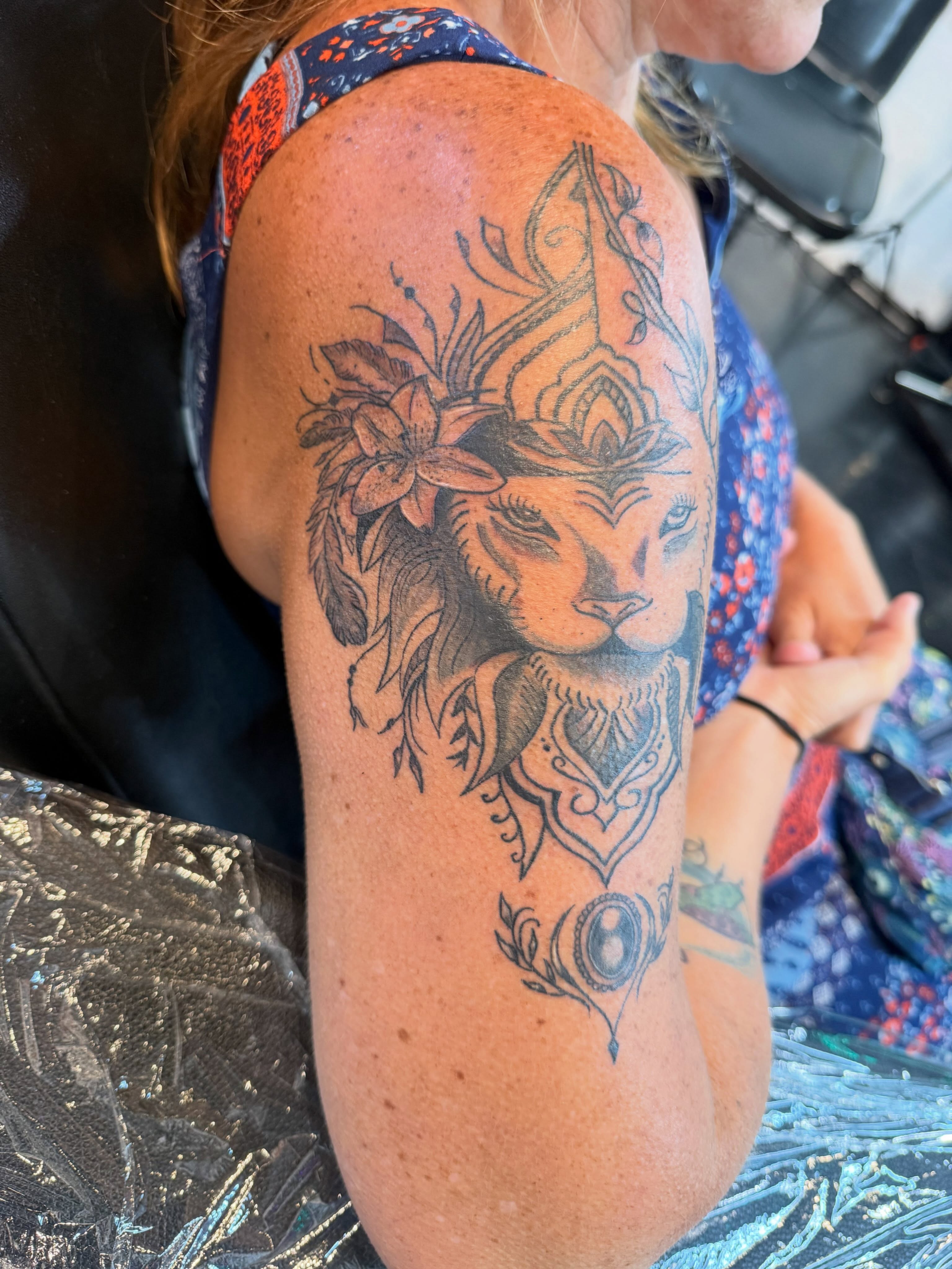 Lion head realism tattoo on the upper arm by Darby Antonucci