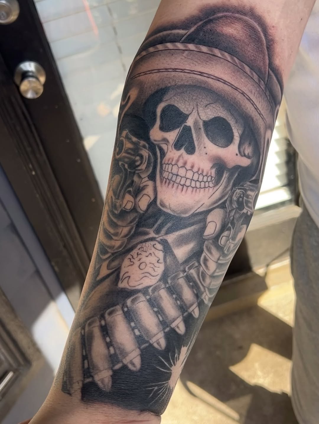Skull with guns and bullets realism tattoo on the forearm by Dallas tx tattoo artist ✝️
