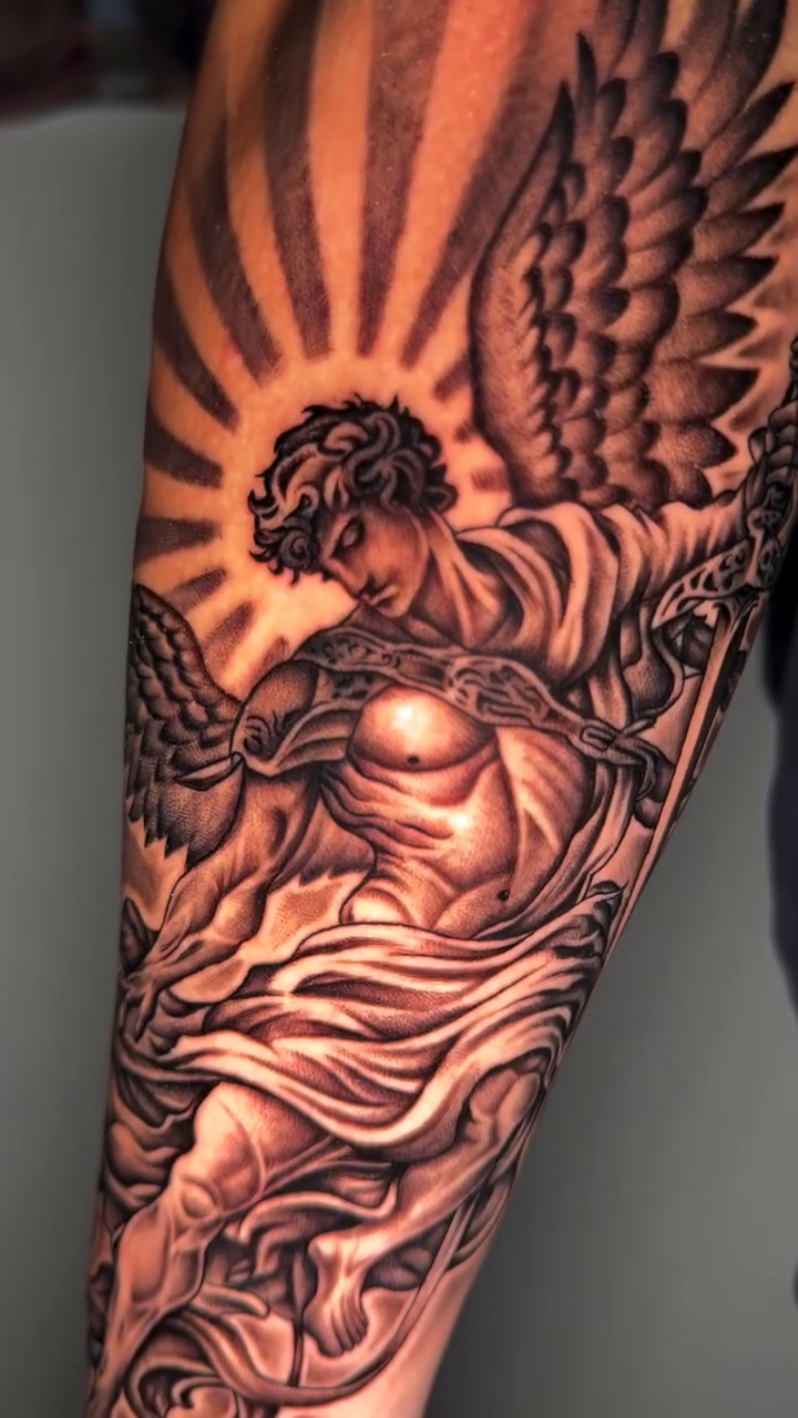 Angel with sunburst realism tattoo by professional tattoo artist