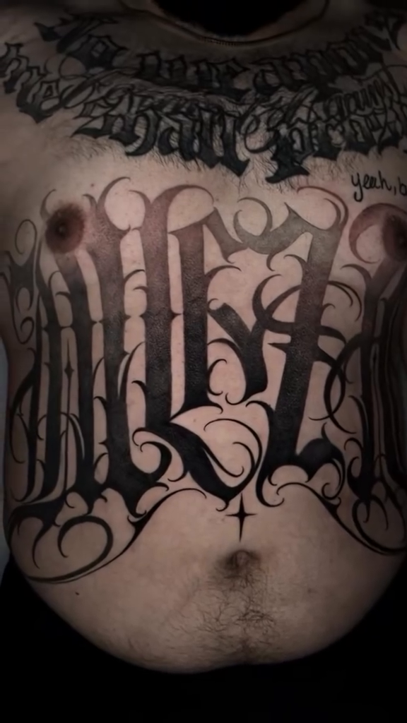 Large gothic lettering on torso Chicano tattoo on the chest by Single Needle ๐ชฉ