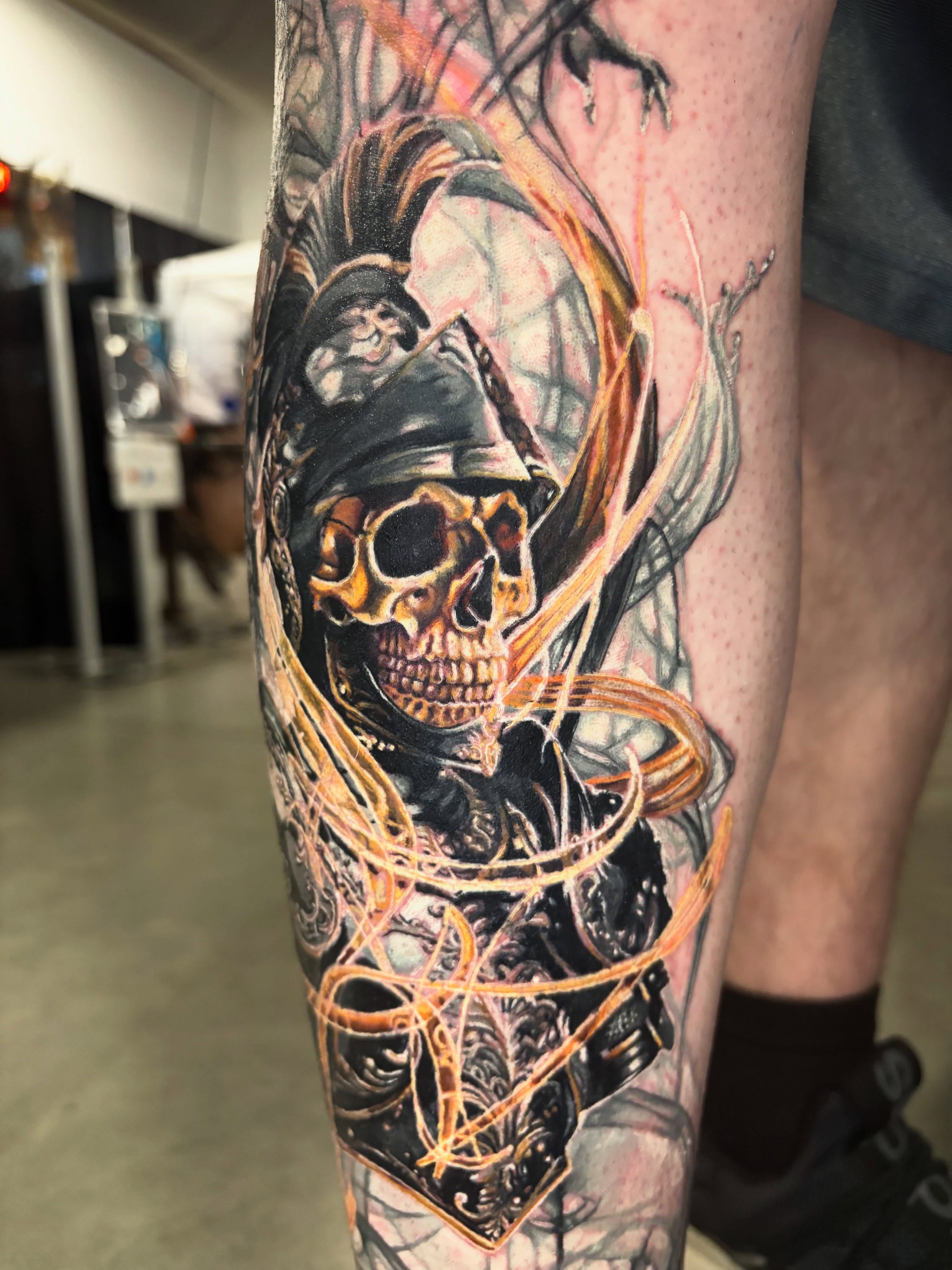 Skull in armor with fiery elements surrealism tattoo on the forearm by Jacee Hamilton
