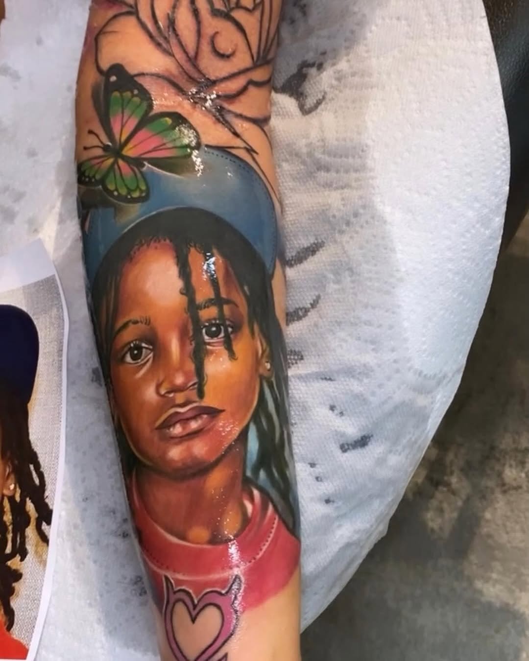 Portrait of a child with butterfly surrealism tattoo on the forearm by Inkby_larry