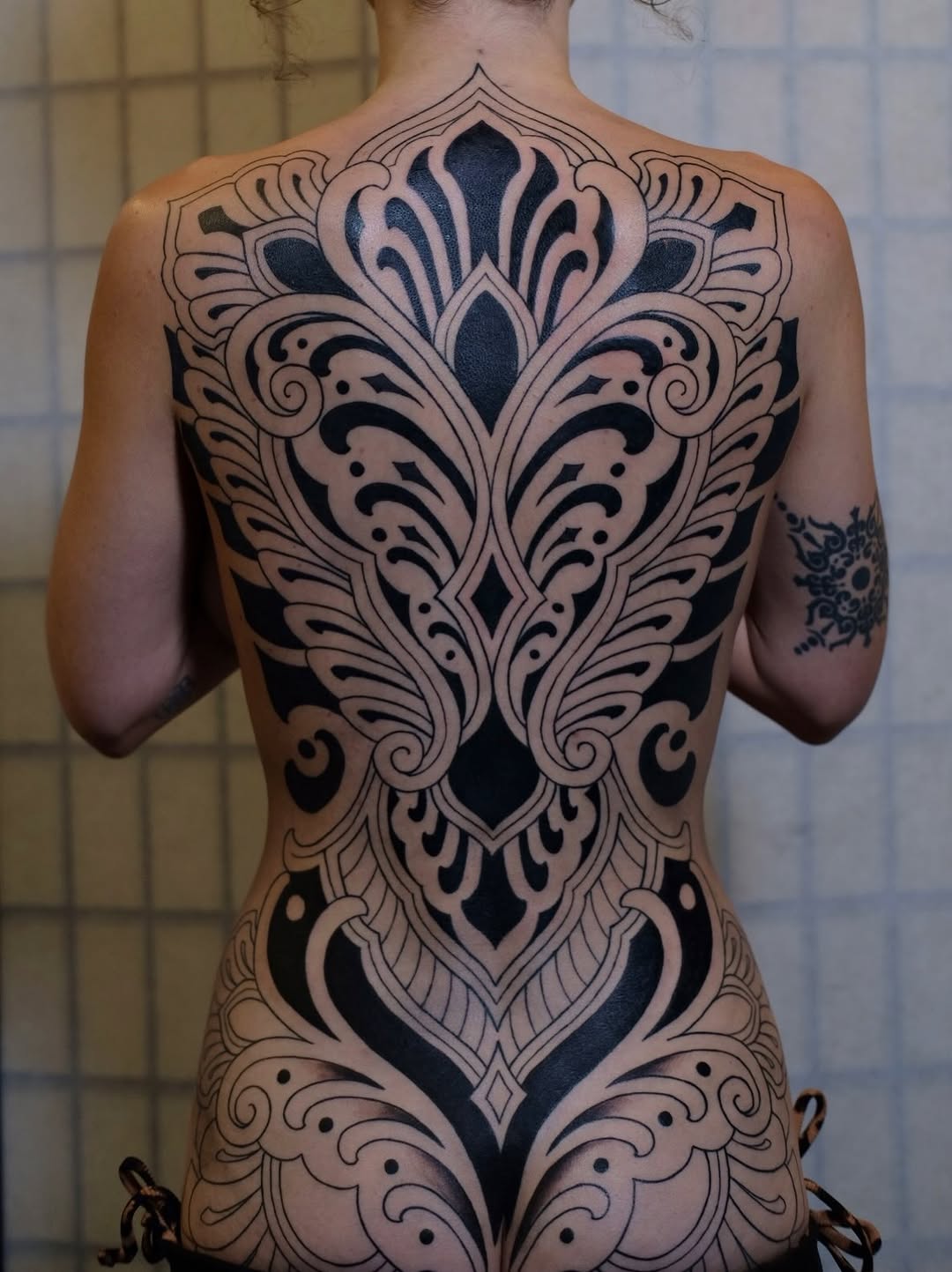 Ornamental back piece tribal tattoo on the back by Owlyn Madrone