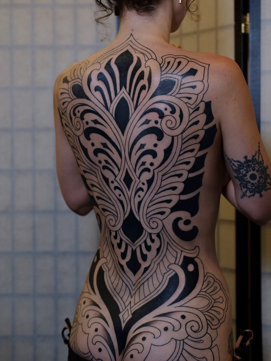 Ornamental full back piece tribal tattoo on the back by Owlyn Madrone