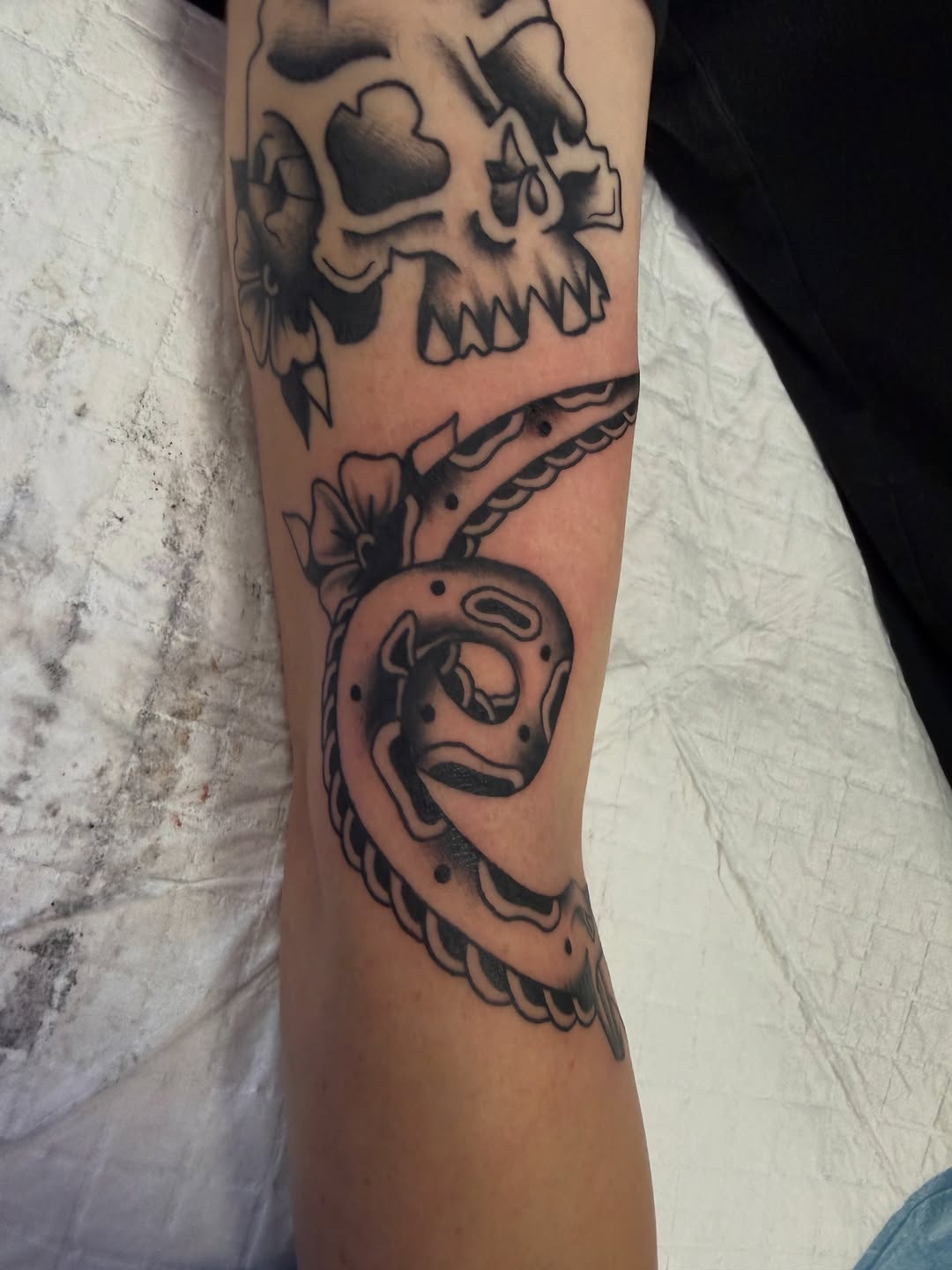 Skull and snake tribal tattoo on the forearm by Nick Tumminello
