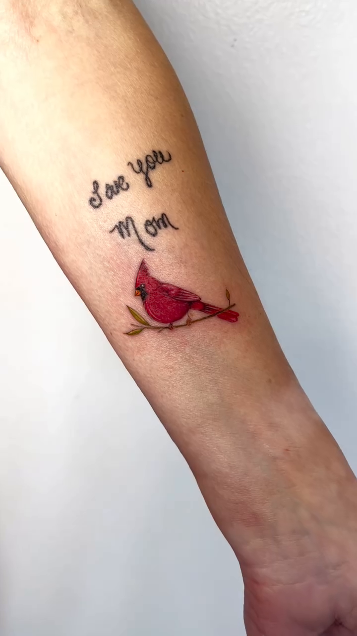 Cardinal bird with text watercolor tattoo on the forearm by kt