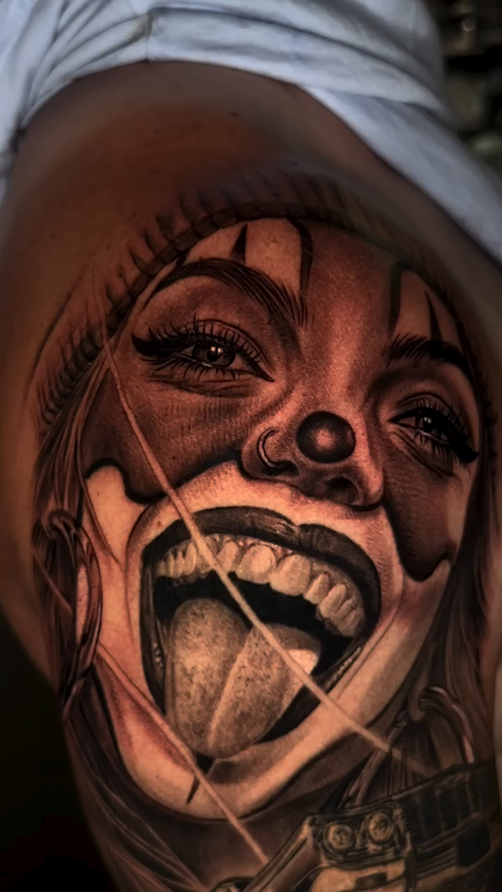 Clown face with tongue out realism tattoo on the upper arm by Jesse White, Mentor, Ohio