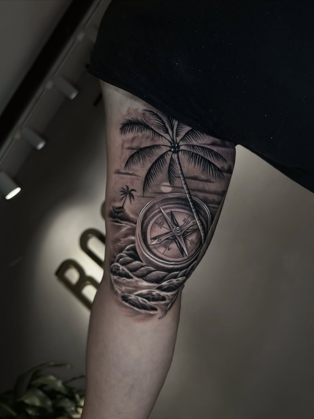 Compass and palm tree landscape surrealism tattoo on the forearm by Clayderman