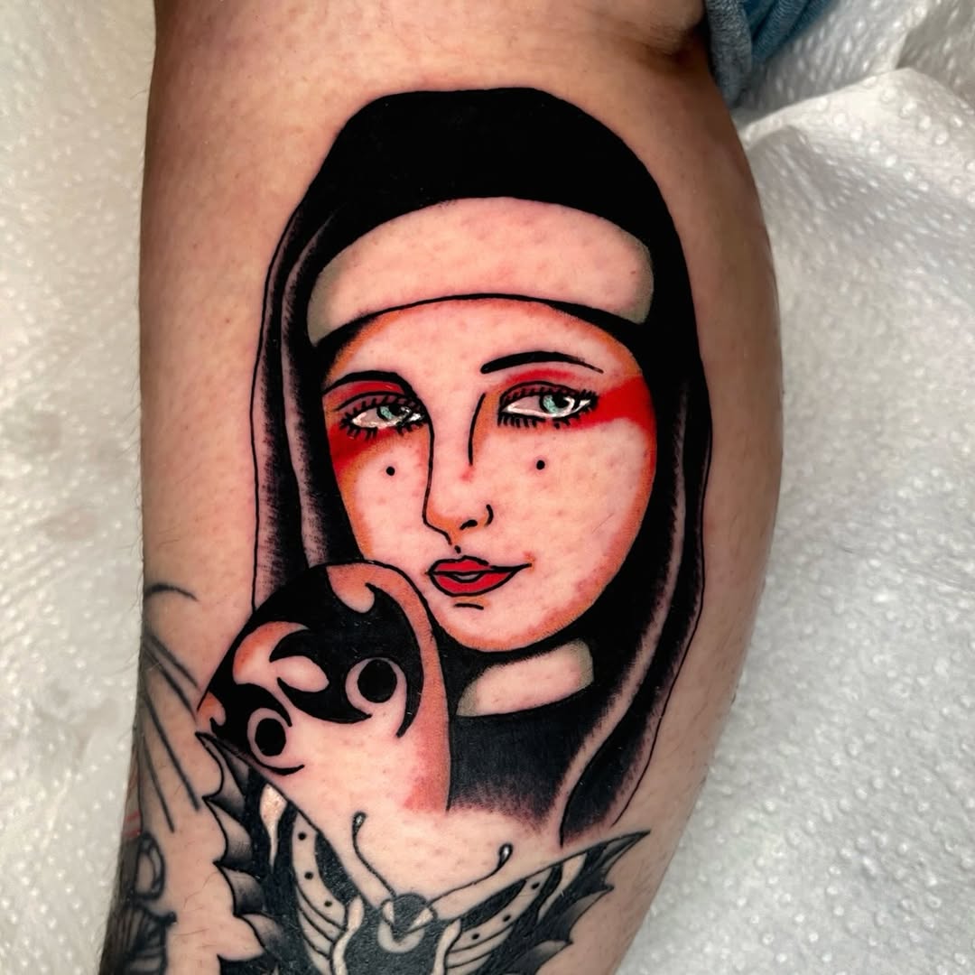Nun holding a mask neo-traditional tattoo on the forearm by Devyn Hightower