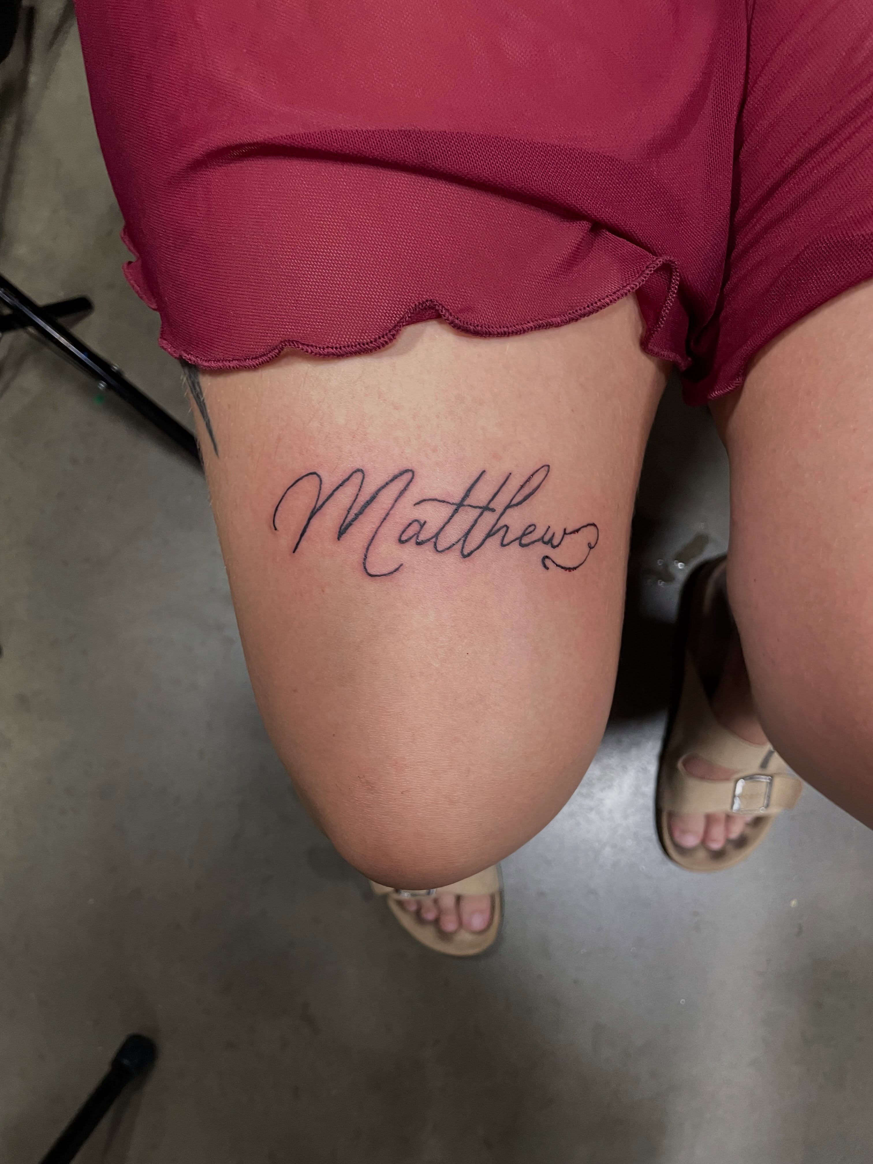 Matthew lettering script tattoo on the thigh by Michael David