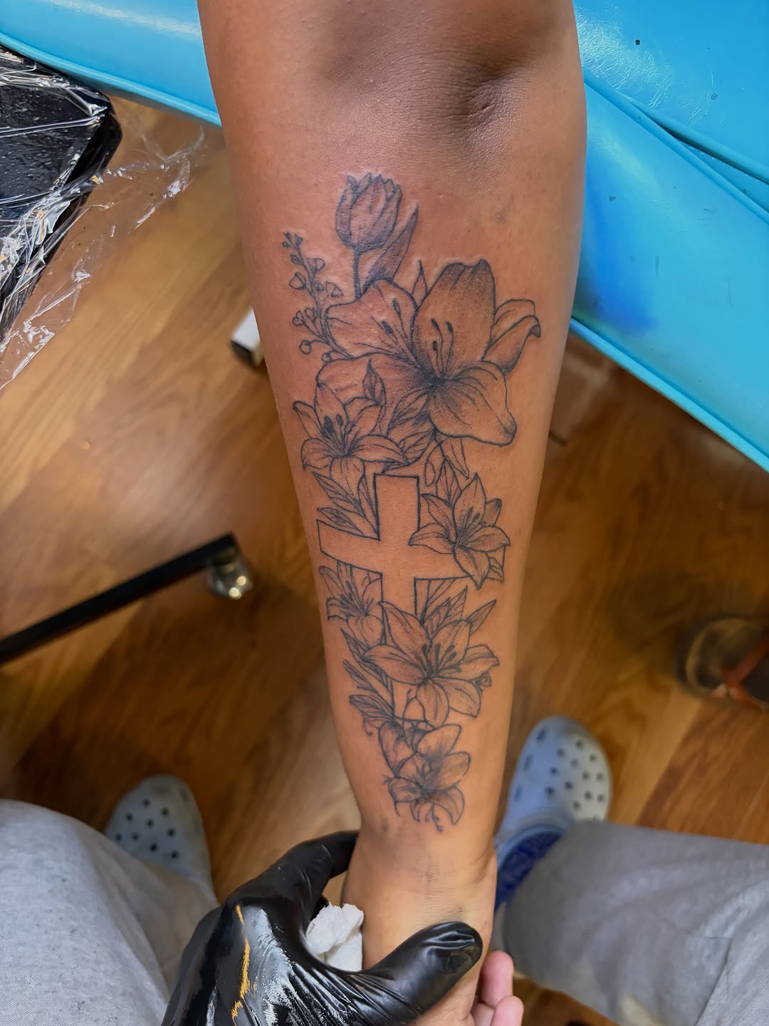 Cross with lilies fine line tattoo on the forearm by Jae the artist🫡