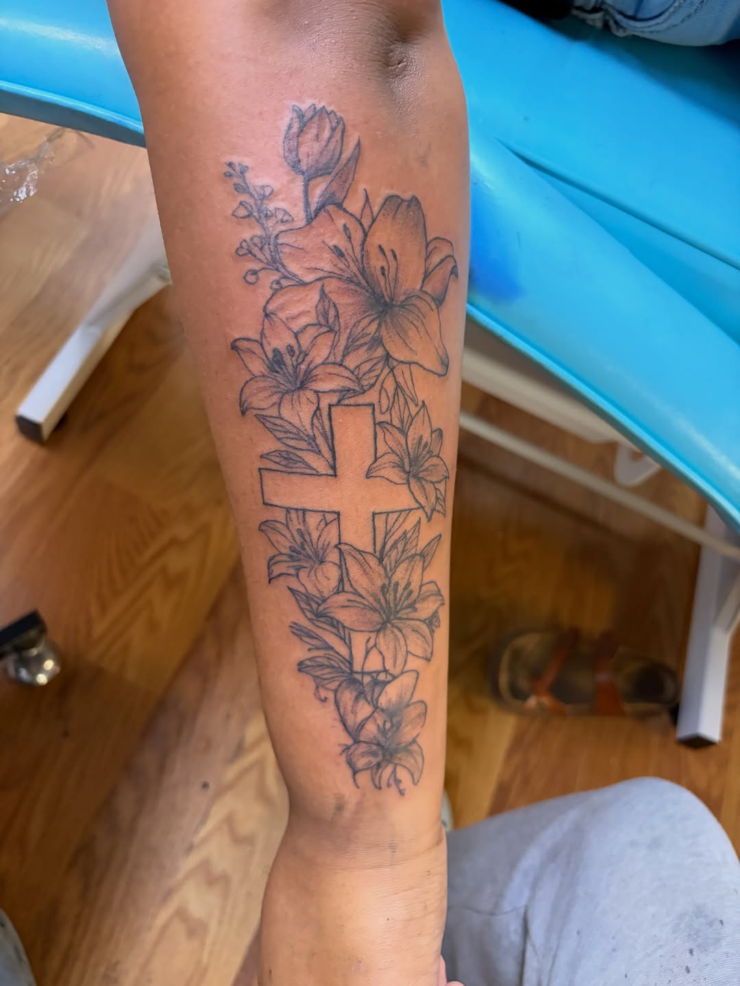 Cross with lilies fine line tattoo on the forearm by Jae the artist🫡