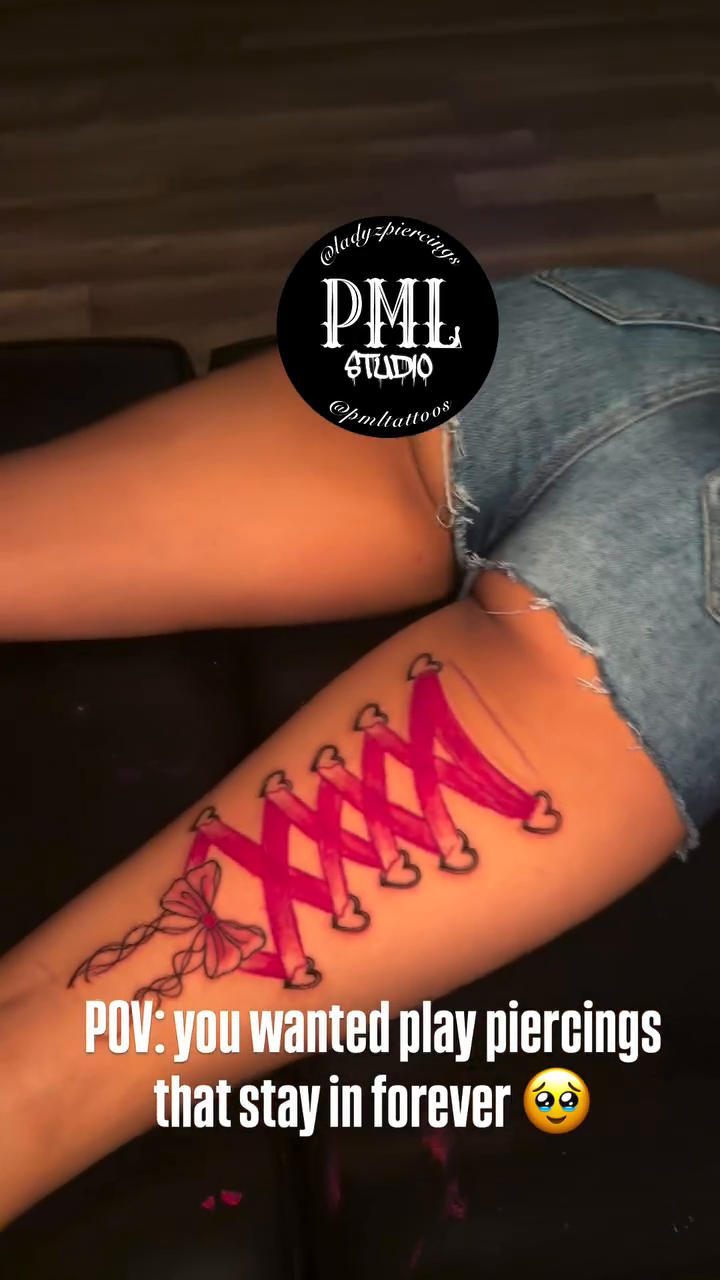 Red corset lace-up tattoo on thigh tattoo on the upper arm by PMLSTUDIO ✡️ Atlanta Licensed Artist, Decatur, Georgia