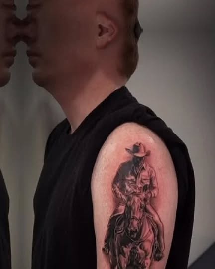 Cowboy on horseback realism tattoo on the upper arm by Janice Heathcote