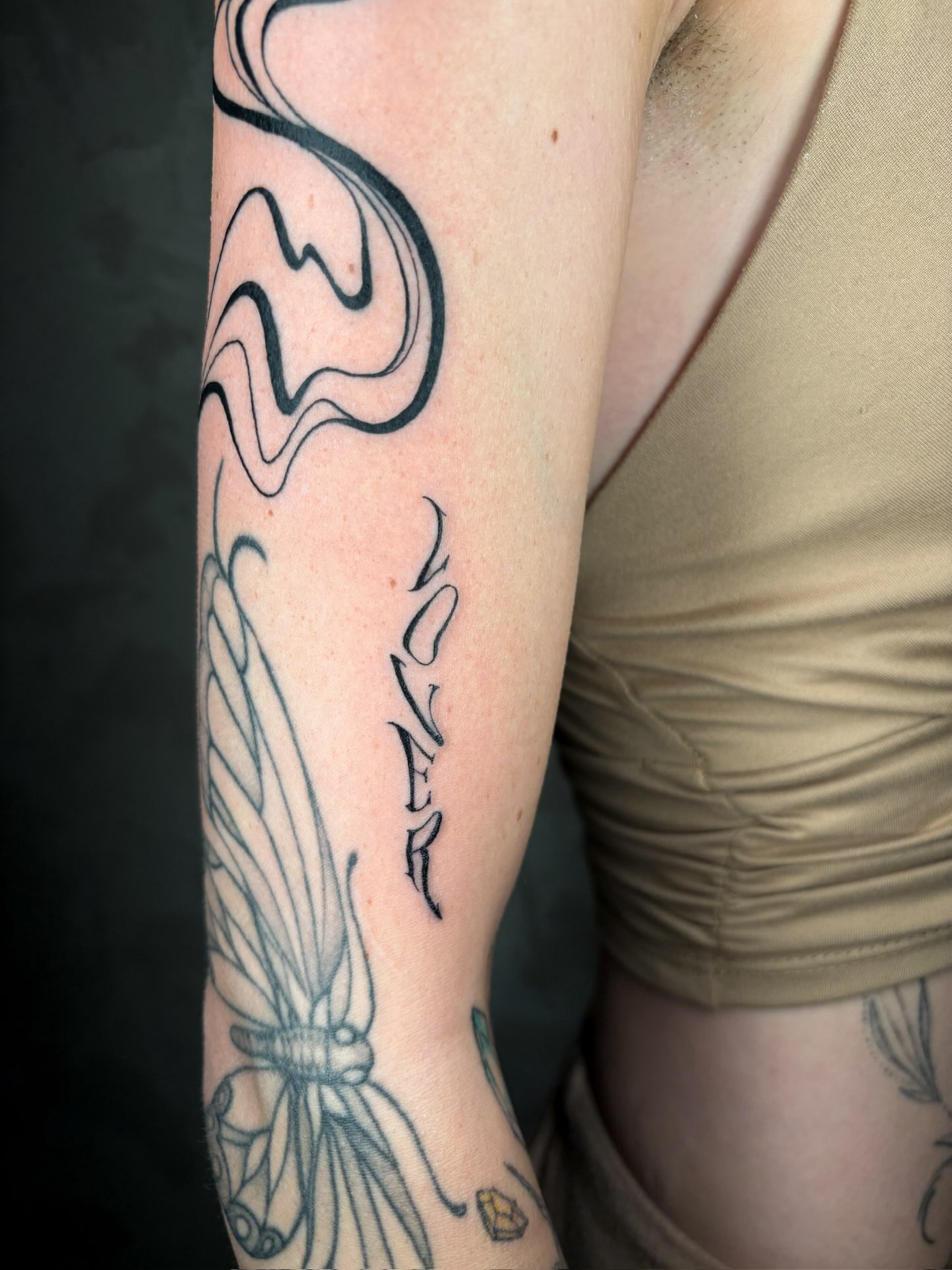 Swirls and butterfly black and grey tattoo on the forearm by Annie